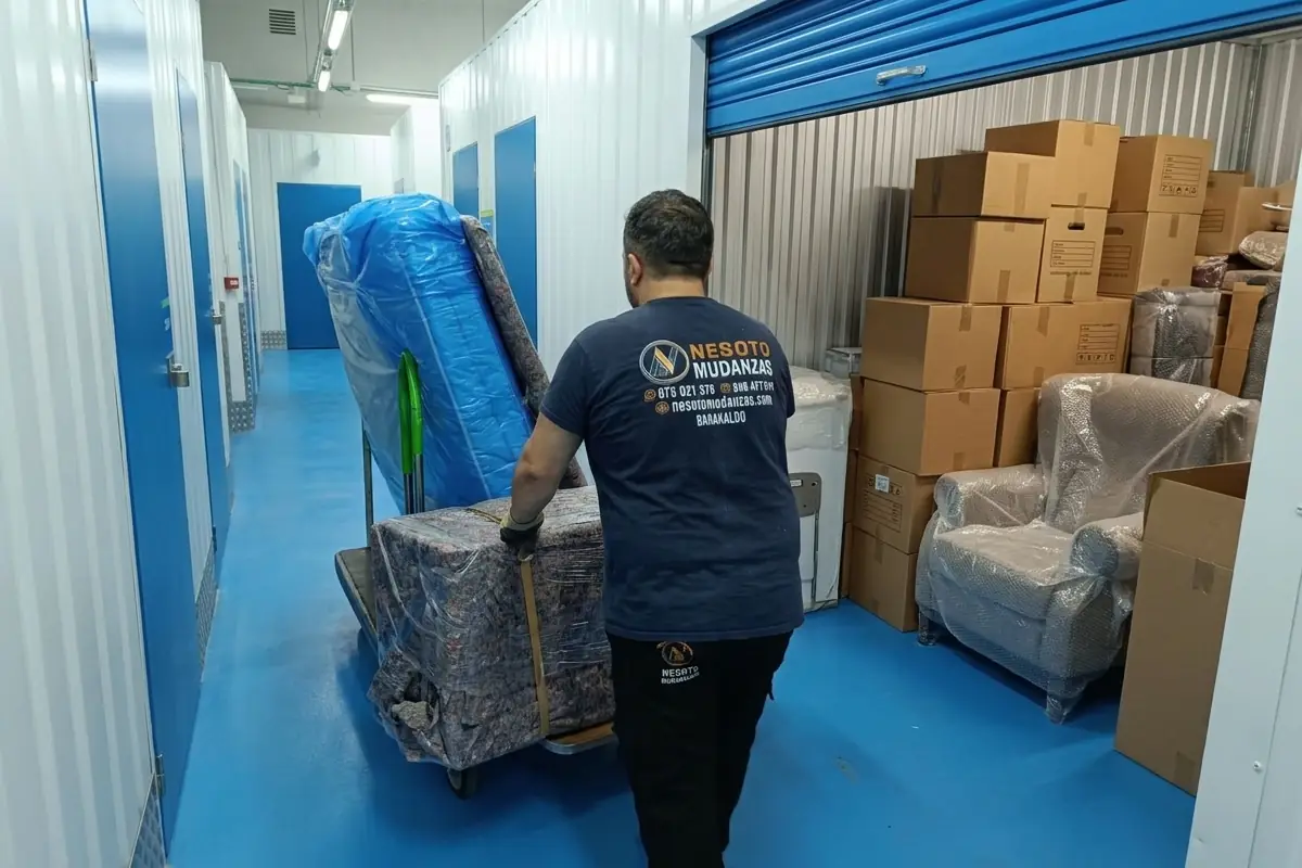 Guardamuebles y trastero en Bilbao: operario de NESOTO guardando muebles protegidos con mantas