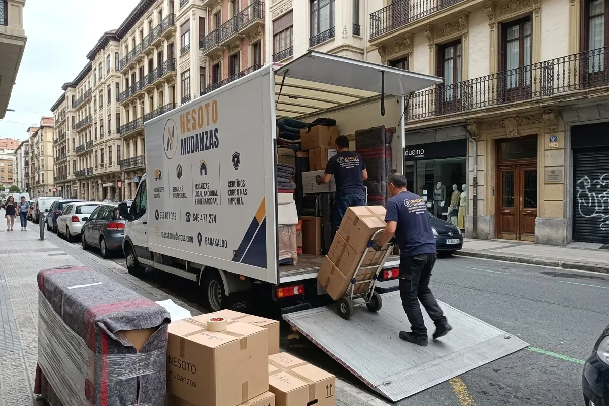 Operarios de NESOTO cargando muebles protegidos y cajas en el camión para una mudanza internacional