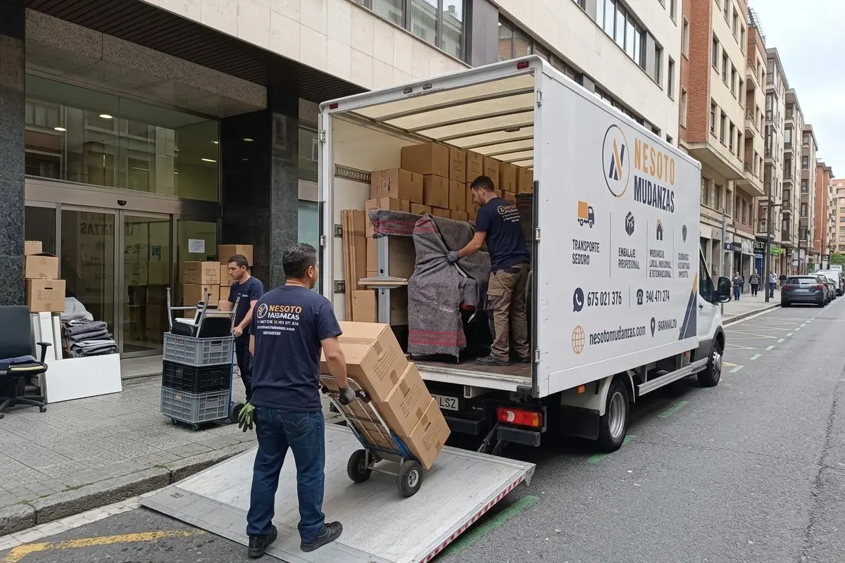 Operarios de NESOTO cargando cajas y equipos de una oficina en el camión de mudanzas
