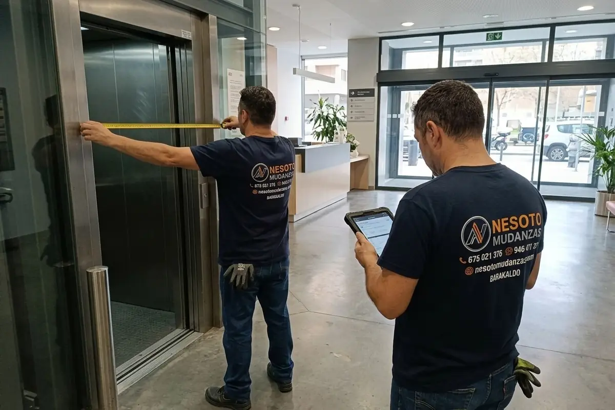 Operarios de NESOTO midiendo el ascensor y los accesos de un edificio de oficinas para el traslado