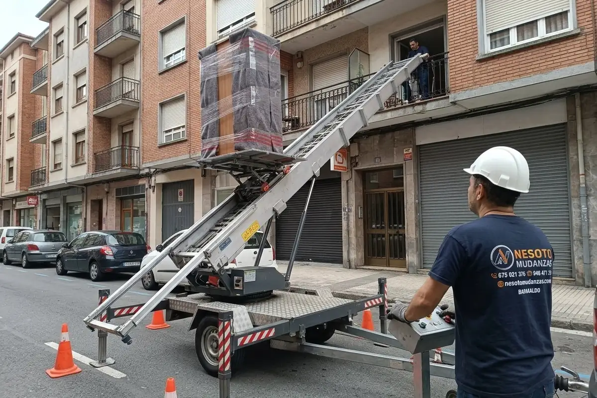 Plataforma elevadora de mudanzas subiendo un armario protegido por la fachada, con un operario de NESOTO
