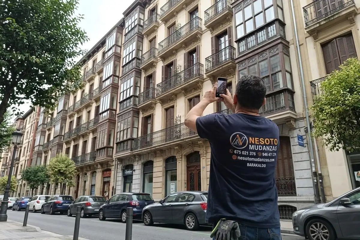 Operario de NESOTO fotografiando la fachada y el balcón para valorar el uso de plataforma elevadora