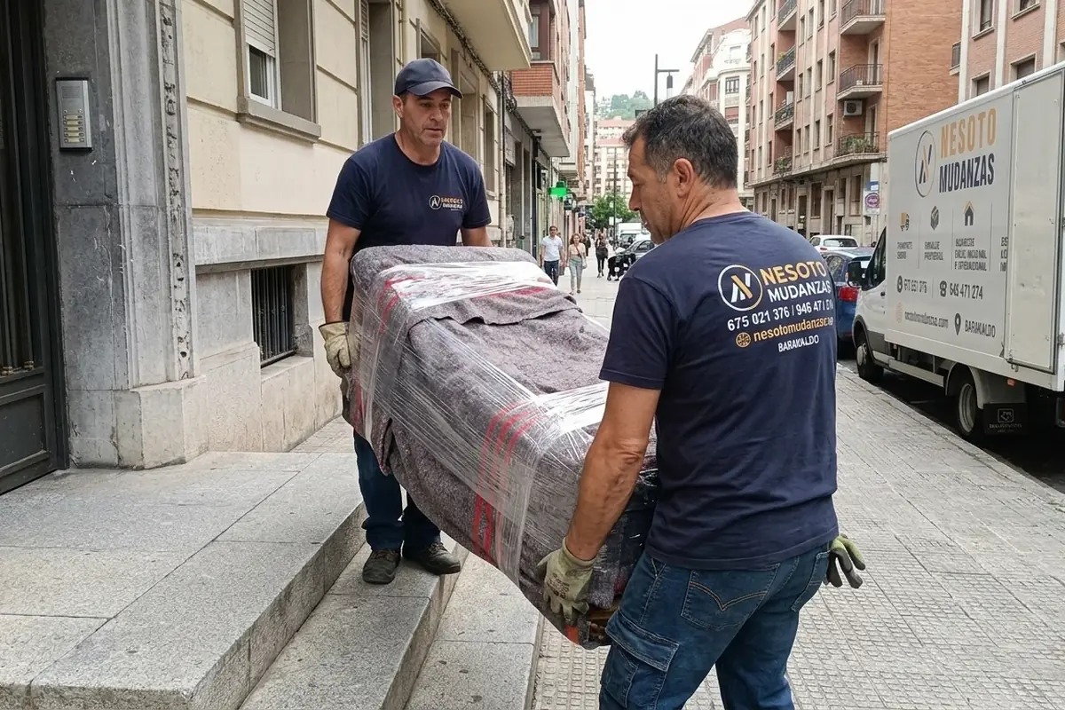 Operarios de NESOTO sacando un mueble protegido por el portal durante el vaciado de un piso